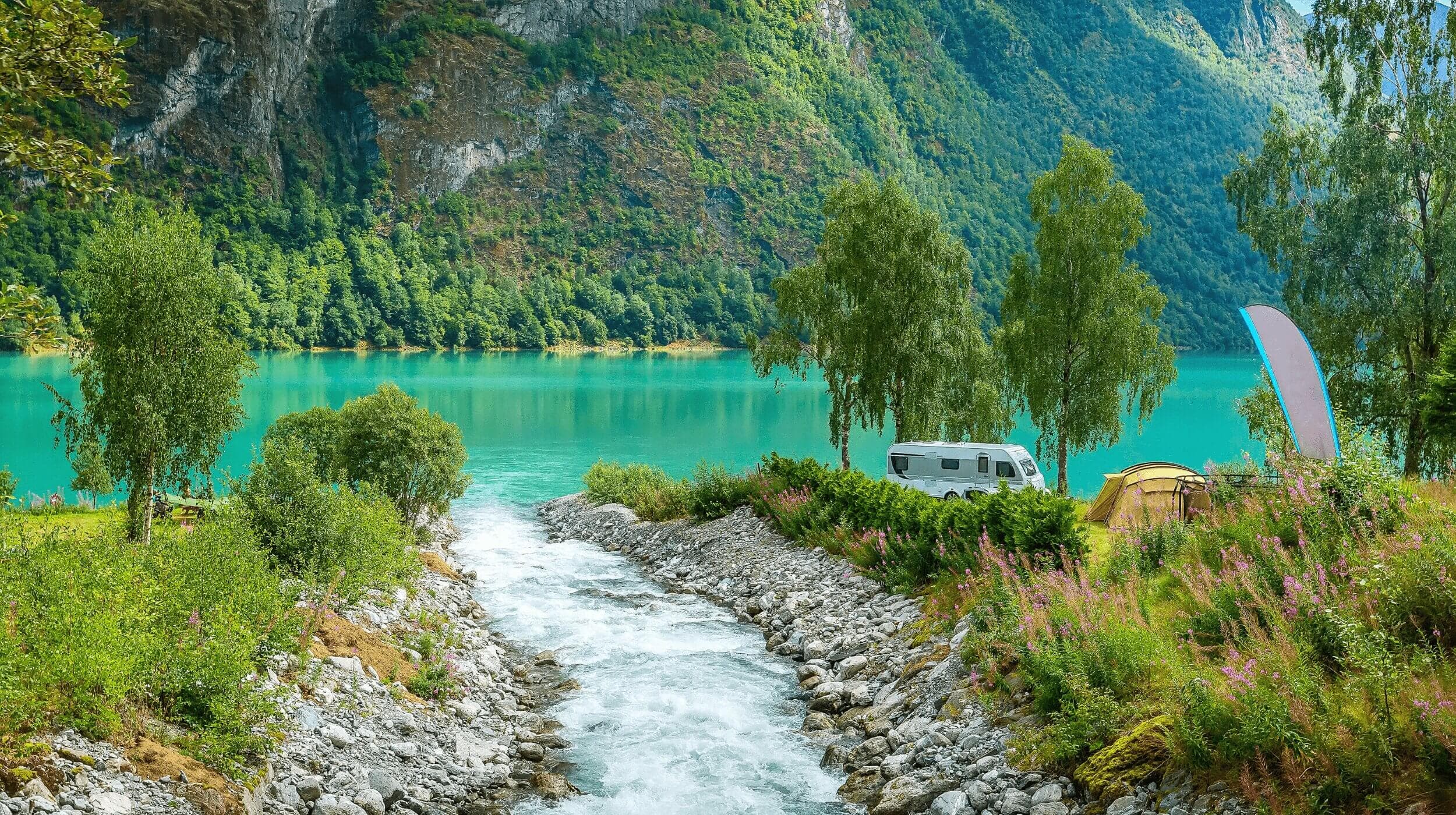 A scenery of a curving river surrounded by green mountains.